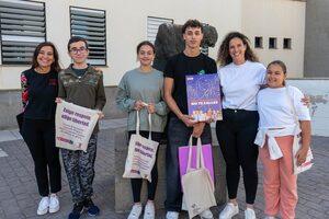 La concejala de Juventud Ruth Martin junto al ganador Noah Perez Cerro mostrando el cartel ganador junto a otros alumnos participantes del IES Guia y una profesora del centro