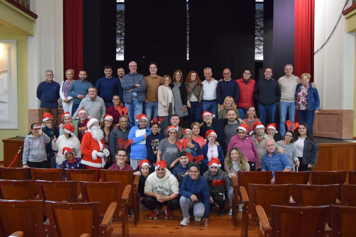 Los usuarios del Centro Ocupacional y el grupo de gobierno en la felicitacion mutua de Navidad en el Teatro Consistorial