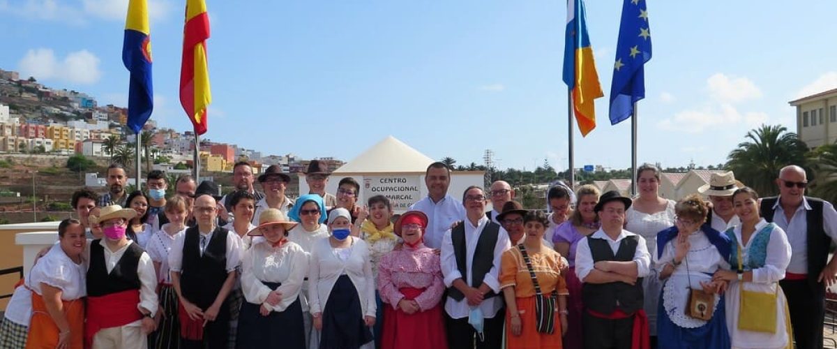 El alcalde Pedro Rodriguez junto a los usuarios y monitores del Centro Ocupacional Comarcal Santa Maria de Guia tras el izado de las banderas