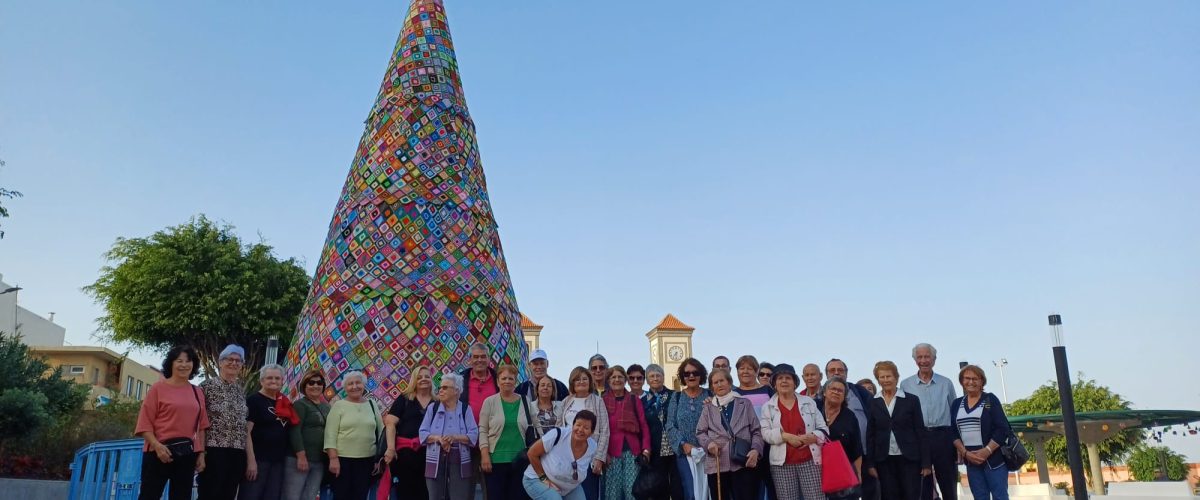 Foto de familia junto al árbol de ganchillo de la plaza de La Atalaya de los participantes en la Ruta de Belenes