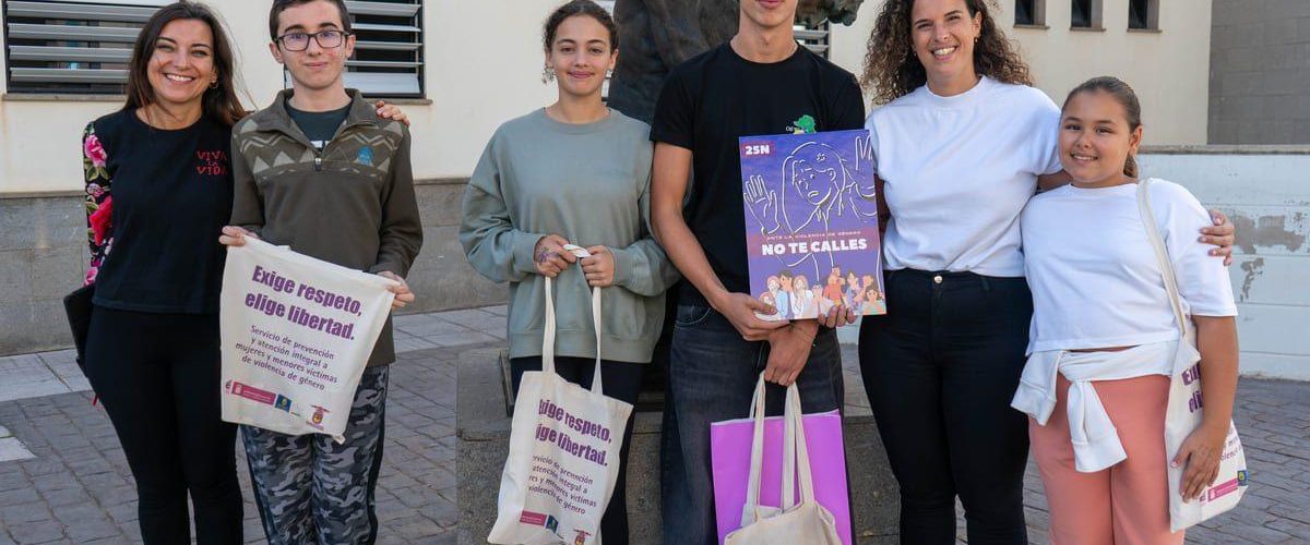 La concejala de Juventud Ruth Martin junto al ganador Noah Perez Cerro mostrando el cartel ganador junto a otros alumnos participantes del IES Guia y una profesora del centro