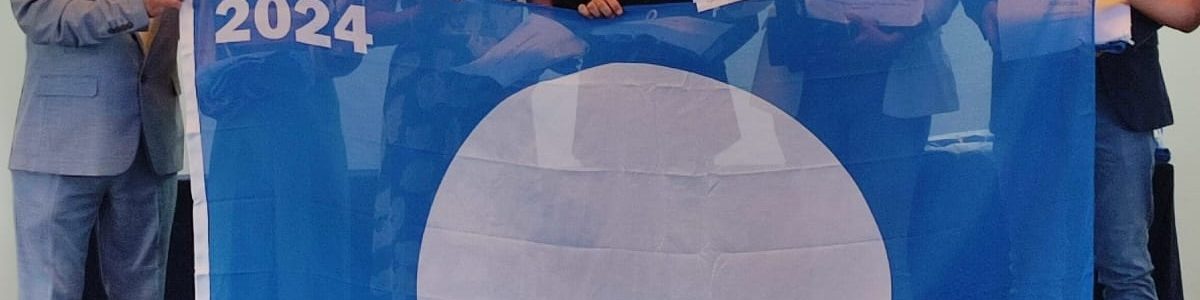 Nuria Vega, segunda por la izquierda, recoge la Bandera Azul para la Bahía de Sardina
