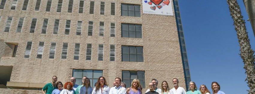 Foto de familia junto a la lona conmemorativa